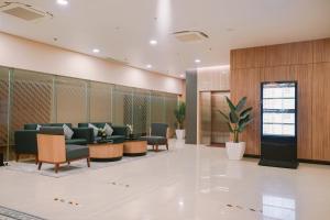 GlagahCordia Hotel Yogyakarta - Hotel Dalam Bandara的大厅里一个带沙发和椅子的等候室