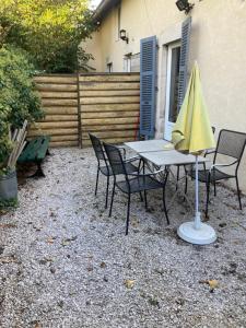卢昂appartement terrasseLouhans centre的一张桌子和椅子,配有黄色雨伞