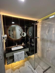 凡城The Conforium Hotel Van的带淋浴、盥洗盆和镜子的浴室