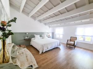 阿莱奥尔Agroturismo Santa Mariana的卧室配有白色的床和椅子