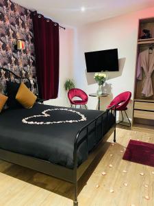 马拉科夫Relax Room proche PARIS Porte de Versailles的一间卧室配有一张床和两张红色椅子