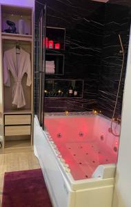 马拉科夫Relax Room proche PARIS Porte de Versailles的一间带黑色墙壁的红色浴缸的浴室