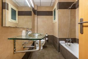 维拉弗兰卡宾纳戴斯Hotel Pere III El Gran的一间带玻璃水槽和浴缸的浴室