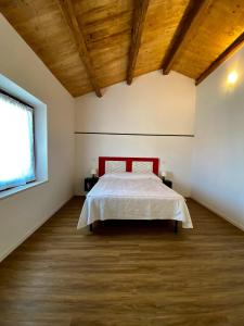 法诺Levante Flat - 100 m from the beach的一间卧室设有一张床和木制天花板