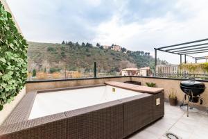 格拉纳达El Generalife cerca centro con Piscina y Barbacoa y Sierra Nevada的建筑物屋顶上的热水浴池