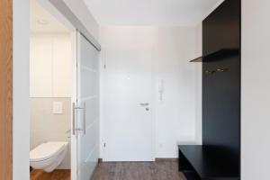 山麓布伦Schickes All-inklusive Apartmentzimmer by RESIDA Asset GmbH的浴室设有白色卫生间和黑色橱柜。