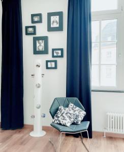 曼海姆高层公寓的墙上挂着照片的房间的蓝色椅子