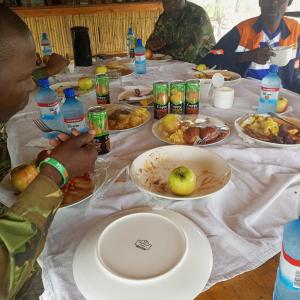 NataMokoka Rest Camp的一群人坐在餐桌旁吃着食物