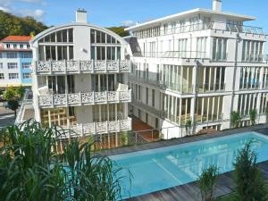 奥斯赛拜-塞林Villa "Johanna" Sellin - WG11 mit Kamin und großer Terrasse的公寓大楼前方设有游泳池