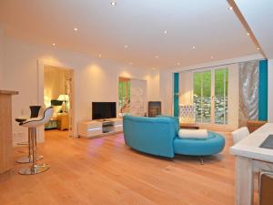 奥斯赛拜-塞林Villa "Johanna" Sellin - WG11 mit Kamin und großer Terrasse的客厅配有蓝色的沙发和电视