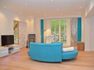 奥斯赛拜-塞林Villa "Johanna" Sellin - WG11 mit Kamin und großer Terrasse的客厅设有蓝色沙发,配有电视