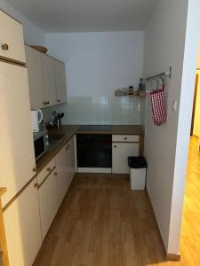 维也纳Apartment4 you的厨房配有白色橱柜和黑色洗碗机