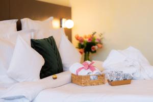 加拉茨Hotel Terra Balneo&Spa的一张带礼物篮子和花瓶的床