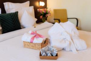 加拉茨Hotel Terra Balneo&Spa的酒店客房,配有毛巾和床上的篮子
