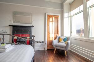 格拉斯哥Pass the Keys Beautiful, traditional 2 bed flat w free parking的一间卧室配有一张床、一把椅子和一个壁炉