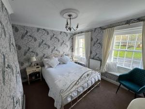 米德尔顿因蒂斯代尔Brunswick House的一间卧室配有一张床和一张蓝色椅子