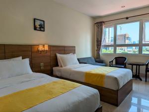 金边中青秋果酒店 True Go Hotel的酒店客房设有两张床和窗户。
