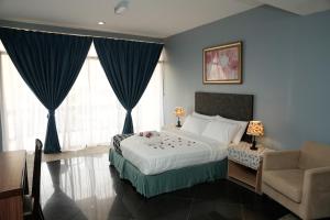 马六甲Putera Island Resort的一间卧室配有一张床、一张沙发和一把椅子