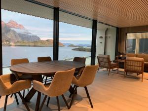 亨宁斯韦尔Stor moderne leilighet i Henningsvær, 70 kvm的一间带桌椅和大窗户的用餐室