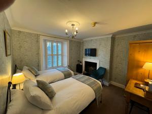 米德尔顿因蒂斯代尔Brunswick House的酒店客房设有三张床和壁炉