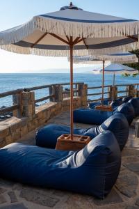 伊罗达Aquila Elounda Village Resort, Suites & Spa的一组蓝色充气剂坐在海洋旁边