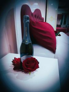 菲乌吉IL NIDO Suite的一瓶香槟和床上的玫瑰