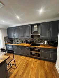 BuckinghamshireHigh Wycombe Centre- 2 bed flat的厨房配有黑色橱柜和木地板