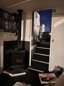 伦敦Narrow Boat moored in London的客房设有壁炉和带炉灶的楼梯。