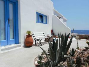 Vlychada BeachVilla Nidito Santorini的坐在白色建筑前的长凳