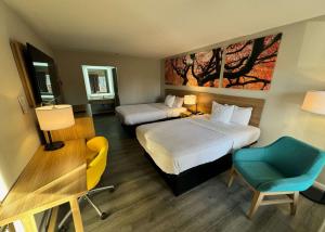 恩波里亚恩波里亚戴斯酒店的酒店客房 - 带两张床、一张桌子和一把椅子