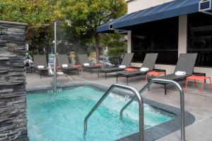 埃默里维尔旧金山/奥克兰湾大桥希尔顿花园旅馆的庭院设有热水浴池、桌椅