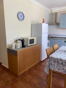 阿尔图拉Apartamento Altura T2的厨房配有带微波炉的柜台和桌子。