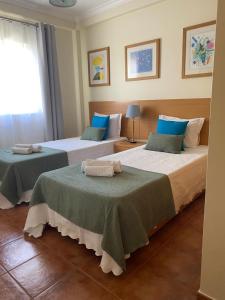 阿尔图拉Apartamento Altura T2的两张位于酒店客房的床,配有毛巾