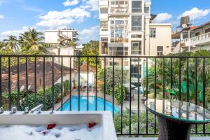 卡兰古特Quality Inn Ocean Palms Goa的一个带游泳池和大楼的阳台