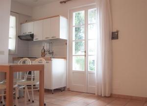 普罗基奥Residence Le Mimose的厨房设有窗户和桌椅