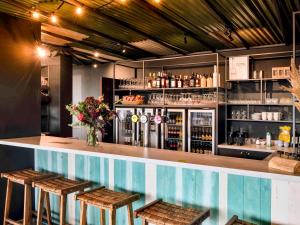布列登ibis Styles Bredene的酒吧设有2张凳子和1个带饮品的吧台