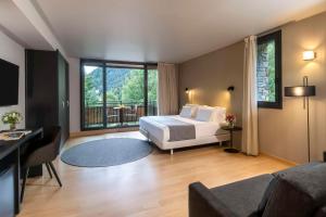 马萨纳NH Collection Andorra Palomé的一间卧室设有一张床和一个大窗户