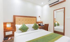 孟买Hotel Delight的一间卧室配有一张大床和镜子