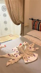 米多恩Hôtel Djerba Authentique - Au centre de Midoun的两只毛巾鸟坐在床上