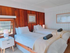 西蒙镇Timber's Ocean House的一间卧室设有两张床、一张桌子和一个窗口
