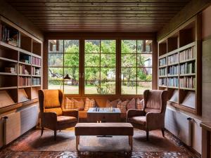 德布里阿赫布格斯塔勒法米丽恩谷特酒店的图书馆配有两把椅子、一张桌子和书架
