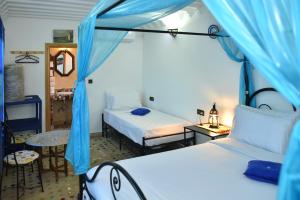 非斯Riad Fes EL KAID的一间卧室配有两张床和蓝色帐篷。