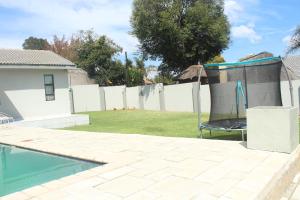 约翰内斯堡Home Away From Home的后院设有游泳池和围栏