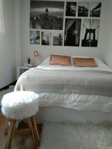 萨拉曼卡VUT Casa Miranda 51的卧室配有一张大白色床和凳子