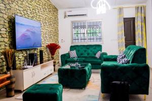 CocodyStunning 4-Bed Villa in cocody engre Abidjan的客厅配有绿色沙发和电视