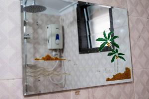 CocodyStunning 4-Bed Villa in cocody engre Abidjan的一面镜子,一面在浴室墙上,一面是棕榈树