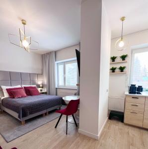 华沙Apartamenty Pokoje Willa Bielany的一间卧室配有一张床和一张红色椅子