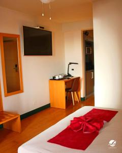 明德卢Pombas Brancas Hotel的一间卧室,床上有红色的弓