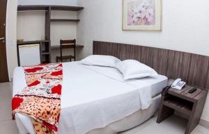 福塔莱萨Ara Mar Praia Hotel的一间卧室配有一张床和一张桌子及电话