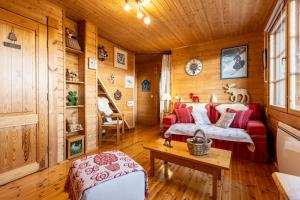 安格勒Le Chalet des Ours - Superbe chalet 4 étoiles的客厅配有红色的沙发和桌子